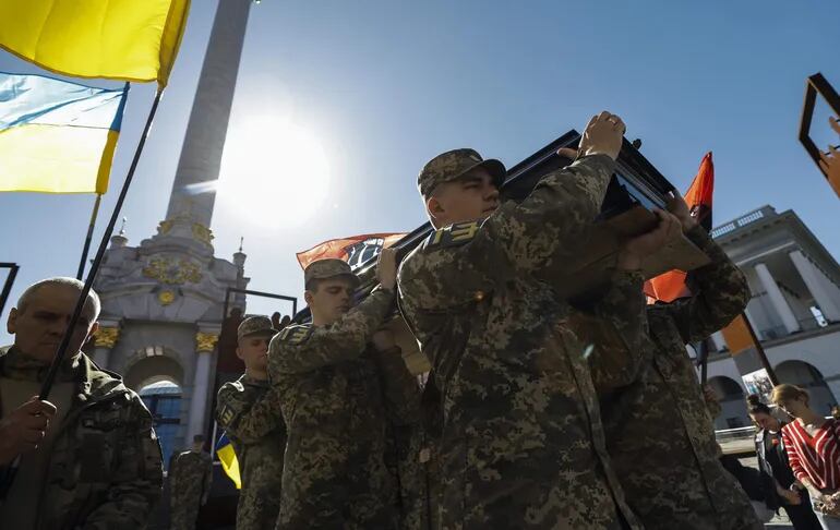 Los camaradas de los fallecidos militares ucranianos Serhii Konoval y Taras Petryshyn llevan sus ataúdes durante una ceremonia de despedida en la Plaza de la Independencia (Maidan Nezalezhnosti) en Kiev, Ucrania.