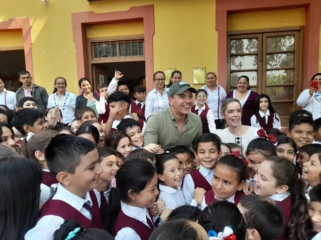 El presidente Santiago Peña y su esposa Leticia Ocampos rodeados de niños de la escuela Ramón Bejarano de Fuerte Olimpo.