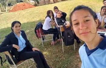 Una alumna de noveno grado hace un selfie en el primer día de clases. A la izquierda se encuentra la profesora de guaraní y castellano, Juana Bautista Bellozo.