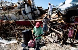 Algunas personas rescatan pertenencias de un barco destruido en la Isla Ábaco, en las Bahamas.