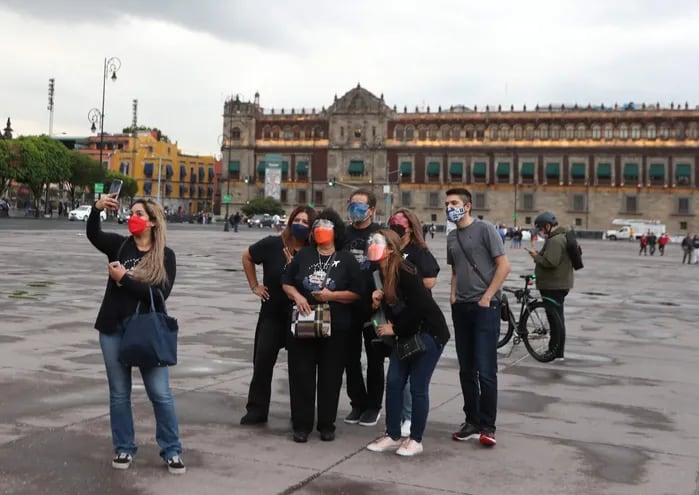 Varias personas con tapabocas se toman una selfi hoy en el Zócalo de la Ciudad de México (México).