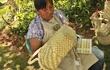 La lideresa indígena Qom Bernarda Pesoa, acá trabajando con totora y con karanda'y, realizando su artesanía.