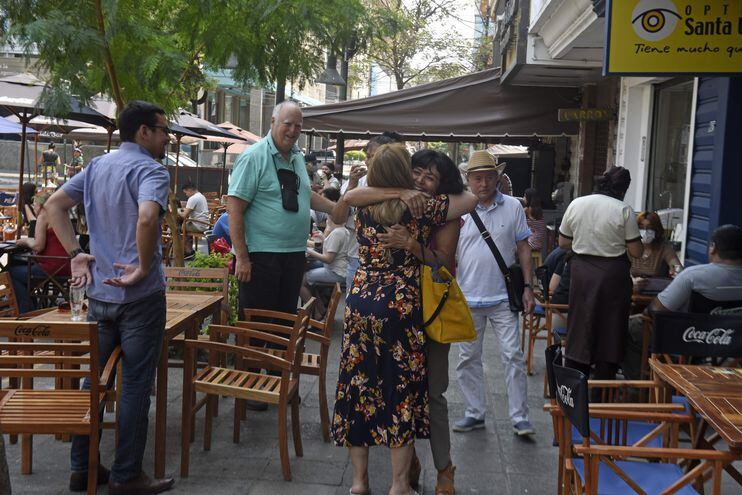 Encuentro alegre entre dos mujeres y la sonrisa de los acompañantes en calle Palma.