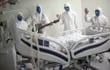 Trabajadores de la salud cantan y rezan junto a un paciente con covid, en un hospital del estado de Pará, Brasil. El país vive momentos críticos.