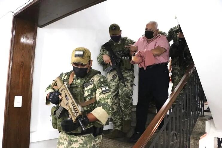 El exdiputado colorado Juan Carlos Ozorio baja las escaleras esposado y escoltado por agentes de la Senad.