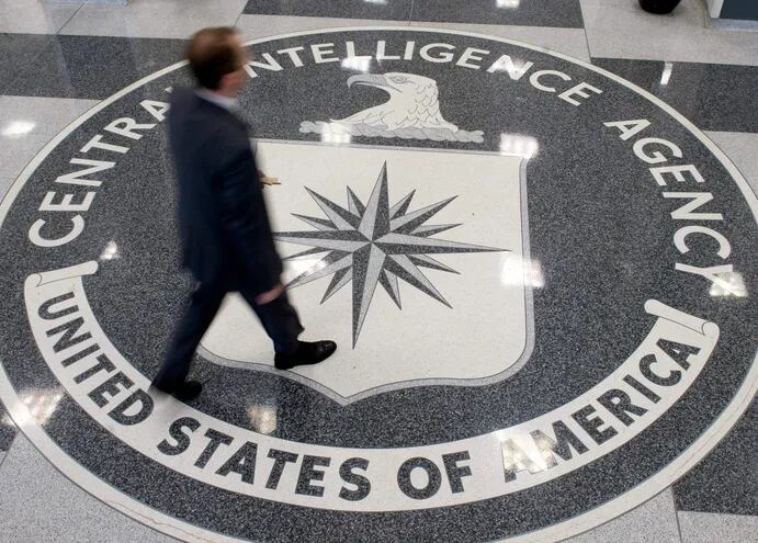 En esta foto de archivo, un hombre camina sobre el sello de la Agencia Central de Inteligencia (CIA), en Langley, Virginia.