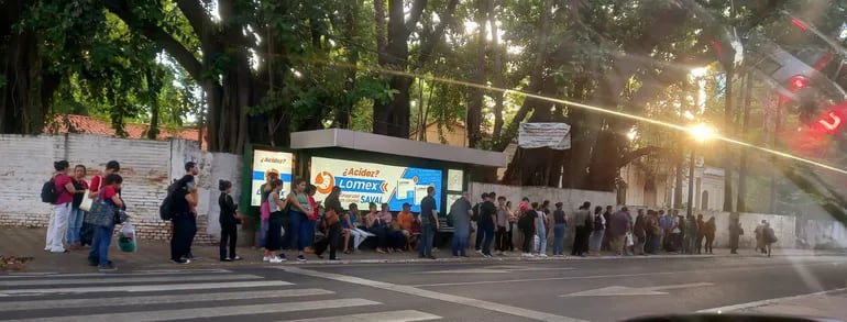 Una parada de buses ubicada sobre la Avda. Mariscal López que se encuentra copada por gente, lo que evidencia las reguladas aplicadas por los transportistas.