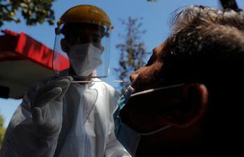Un trabajador de la salud toma una muestra a un paciente, en Santiago de Chile.