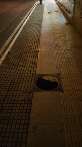 Dos agujeros en una vereda del centro de Asunción.