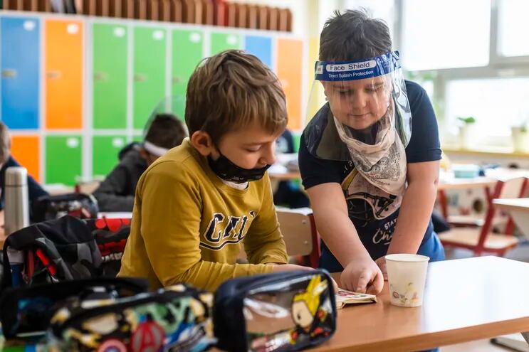 Alumnos de primaria con mascarillas y  protectores faciales en un colegio de Varsovia, Polonia.