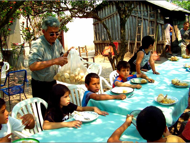Monseñor Adalberto Martínez distribuía alimento entre los niños de un comedor, en 2006.