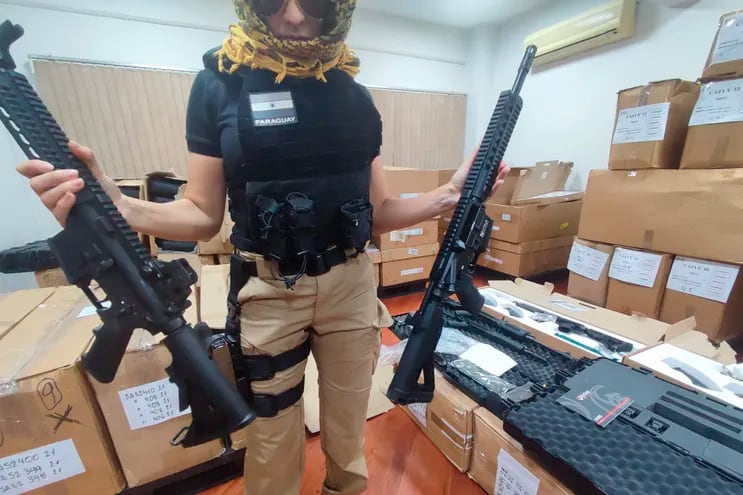 Una agente de la Senad muestra rifles incautados en el marco del operativo "Dakovo".