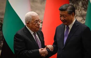 El presidente de la Autoridad Palestina, Mahmud Abbas (i) saluda al mandatario de China, durante una ceremonia en PEkín.  (AFP)