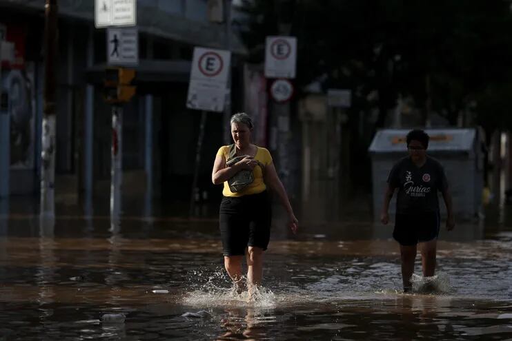 Vecinos de Porto Alegre caminan por una zona inundada de la ciudad, el pasado miércoles.