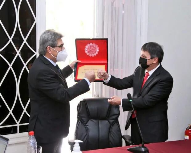El diputado Roberto Eudez González (izq.) recibe una condecoración por su gestión al frente del CM, de parte de su nuevo presidente, Oscar Paciello.