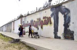 tres-ninos-caminan-junto-a-un-muro-con-esloganes-del-grupo-yihadista-estado-islamico-ei-en-mosul-irak-efe-02136000000-1550945.jpg