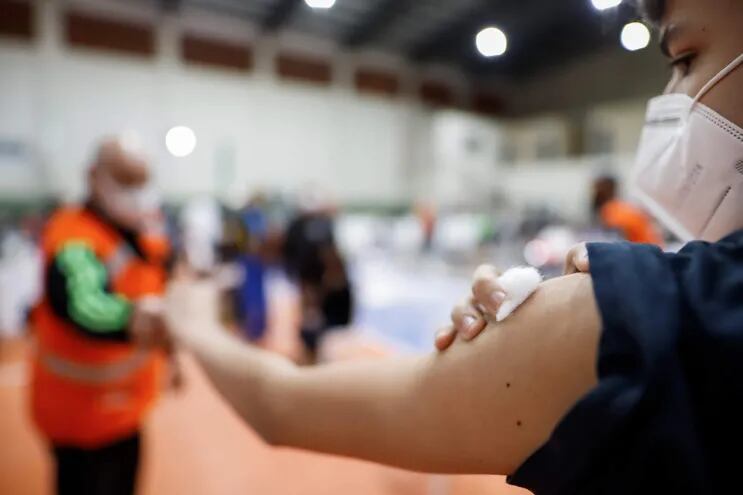 Un adolescente muestra el brazo tras recibir una vacuna en la Secretaría Nacional de Deportes.