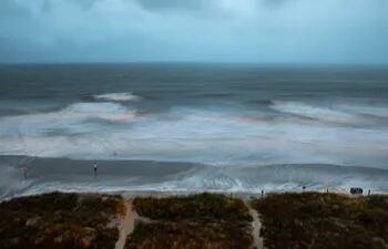 El viento agita grandes olas mientras una persona se para en la orilla cuando el huracán Isaias se acerca a North Myrtle Beach, el 3 de agosto.