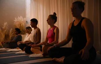 Practicantes de yoga asisten a una sesión en un estudio al este de Londres, Reino Unido.