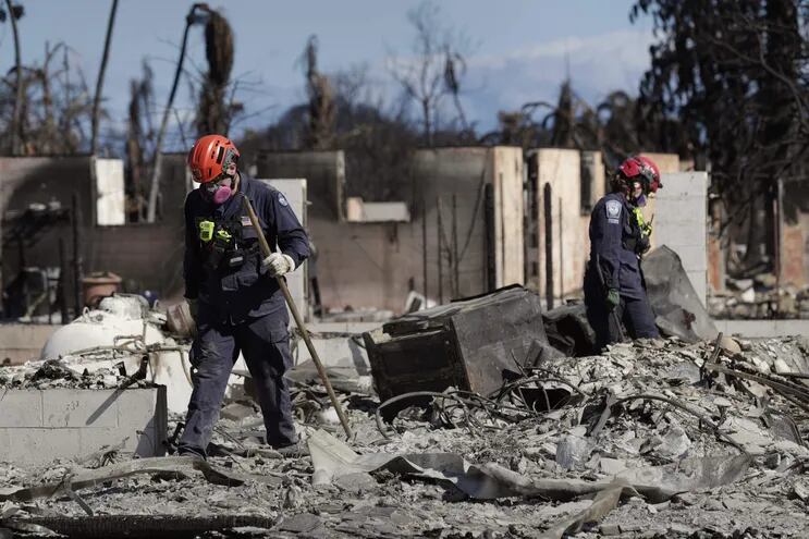 Fotografía cedida por el Departamento de Defensa de EE.UU. de miembros del Equipo de Búsqueda y Rescate Urbano de la Agencia Federal para el Manejo de Emergencias que recorren una zona destruida por los incendios, en Lahaina, Hawai (EE.UU.).