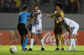 El árbitro chileno Piero Maza (i) señala una falta en un partido entre Aucas y Nacional por la Fase 1 de la Copa Libertadores en Quito, Ecuador.
