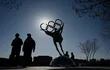 Gente camina cerca de una estatua con los anillos olímpicos, en las inmediaciones del Comité Organizador de Pekín, en Shougang Park, una de las sedes para los Juegos Olímpicos de Invierno de Pekín 2022. (Imagen por Noel Celis / AFP)