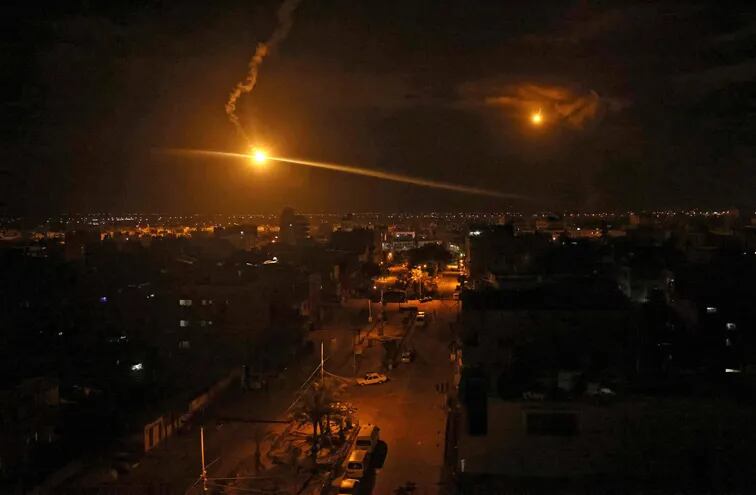 Bengalas lanzadas por fuerzas israelíes iluminan el cielo sobre la ciudad de Rafah, en la Franja de Gaza, este domingo.
