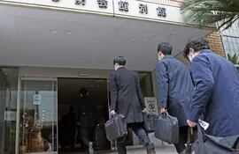 Agentes de la fiscalía de japonesa ingresan a la sede del Partido Democrático Liberal.