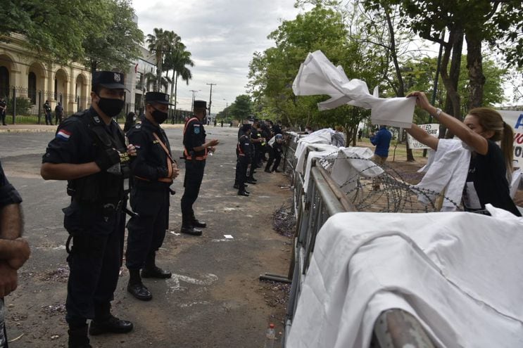 Una doctora coloca su bata sobre las cercas rodeadas de alambre de púas que fueron puestas en las inmediaciones del Congreso Nacional esta mañana.