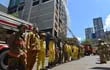 Formación de bomberos, al pie del edificio Flytec de Ciudad del Este que se ardió en llamas durante cinco días.