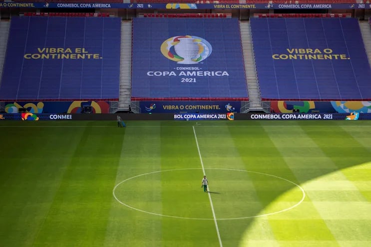 Empleados trabajan hoy, en el campo del estadio Mané Garrincha que acogerá la inauguración de la Copa América en la ciudad de Brasilia (Brasil). La Copa América 2021 ser realizará en cuatro ciudades de Brasil del 13 de junio al 10 de julio.