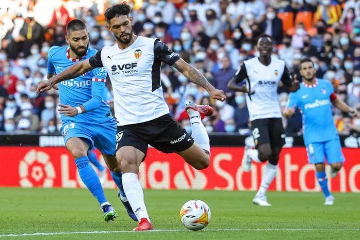 El zaguero paraguayo Omar Alderete, del Valencia, rechaza el balón ante la presencia del delantero belga Yannick Ferreira-Carrasco, del Atlético Madrid.