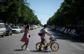 Una pareja cruza una calle después de comprar productos en el área residencial de Yilanyuan, que está cerrada bajo llave después de un nuevo brote de coronavirus COVID-19 cerca del mercado cerrado de Xinfadi, en Beijing.