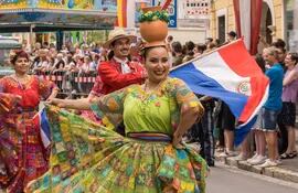 Una mujer con vestimenta tradicional paraguaya y el cántaro en la cabeza.