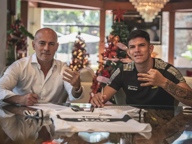 Miguel Cardona, presidente de Olimpia, y Junior Barreto (d) durante la firma del contrato del jugador, el primer refuerzo del Decano para 2023.