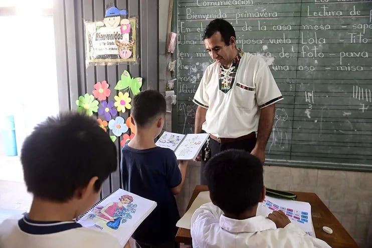 El profesor Toribio Ojeda practica la lectura con sus alumnos del primer grado, en la escuela Sotero Colmán del Bañado Sur, en Asunción.