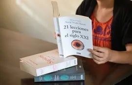 Una mujer lee el libro 21 lecciones para el siglo XXI, de Yuval Noah Harari.