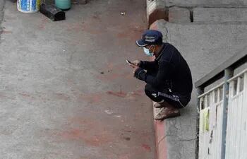 Un hombre usa su teléfono móvil en una carretera en el centro de Yangon, Myanmar, el 4 de febrero de 2021.