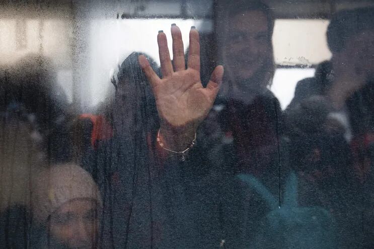 Una mujer pone su mano en la ventana dentro de un autobús en la evacuación de ucranianos a Kiev.