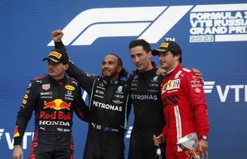 El ingles Lewis Hamilton, con el puño levantado, conquistó el Gran Premio de Rusia y llegó a su victoria número 100 en la Fórmula 1. A lado aparecen en el podio el holandés Max Verstappen (i) y el español Carlos Saiz (d), segundo y tercero, respectivamente en la clasificación final (EFE).