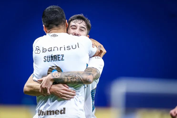 El paraguayo Mathías Villasanti (d), jugador de Gremio de Porto Alegre, festeja con el uruguayo Luis Suárez el gol contra Cruzeiro por la revancha de los octavos de final de la Copa Brasil.