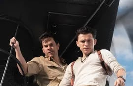 Tom Holland como Nathan Drake (d) y Mark Wahlberg (i) como Victor Sullivan, durante una escena de la película "Uncharted: fuera del mapa", que llega hoy a los cines.