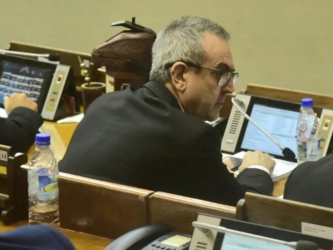 Yamil Esgaib, un hombre adulto, de pelo canoso, con anteojos y traje oscuro, sentado en su banca en la Cámara de Diputados.