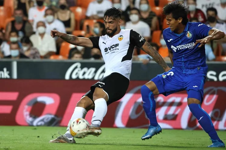 Omar Alderete, defensor paraguayo del Valencia, rechaza el balón ante la presencia del delantero mexicano José  Macías, del Getafe.