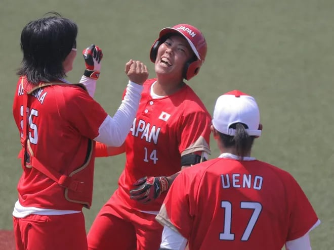Yukiko Ueno (17) festeja con otras dos jugadoras el triunfo de Japón en el sóftbol en el comienzo de los Juegos Olímpicos.