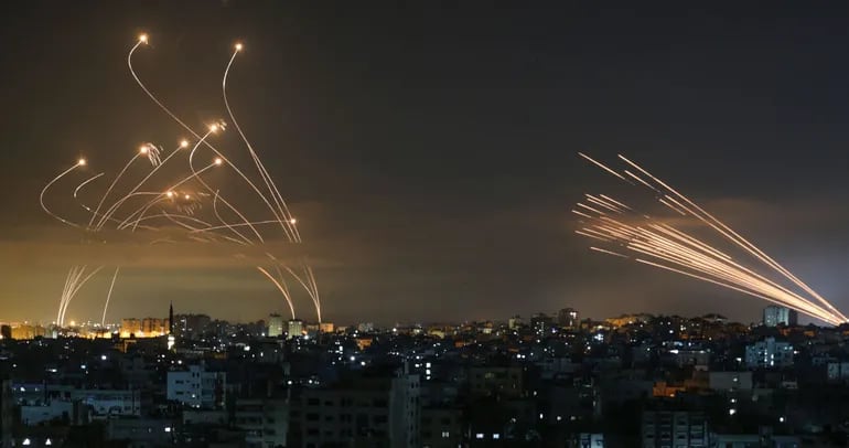 Cohetes lanzados por grupos radicales palestinos desde Gaza (der.), mientras se activa el sistema defensivo antimisiles israelí (izq.), conocido como Cúpula de Hierro, para contrarrestar el ataque.