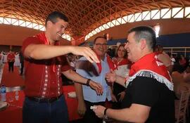 El presidente de la República, Santiago Peña (izq.) se acerca a abrazar al titular de la ANR, Horacio Cartes, ayer en Itapúa.