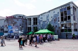 La gente hace cola en una distribución de alimentos organizada por voluntarios en la ciudad de Mariúpol  en medio de la acción militar rusa en curso en Ucrania.