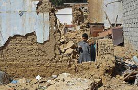 Un niño se encuentra entre los escombros de las casas derrumbadas tras un terremoto en el remoto distrito montañoso de Harnai.