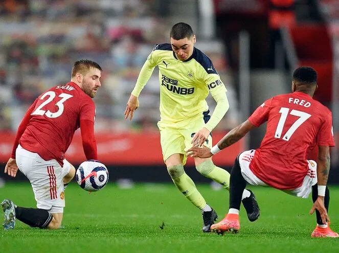 Miguel Almirón intenta avanzar con el balón ante el inglés Luke Shaw y el brasileño Fred, durante el partido que Newcastle perdió ayer 3-1 en campo del Manchester United. (AFP)